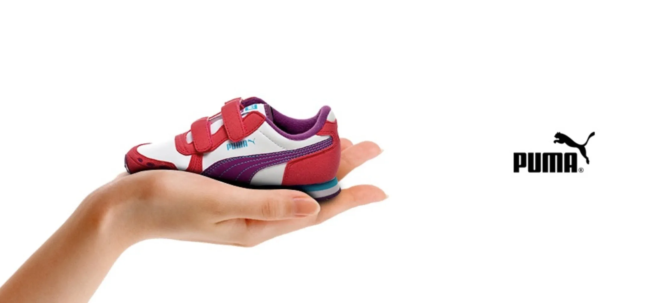 Product banner: a hand holding a small red and purple Puma sneaker on white.