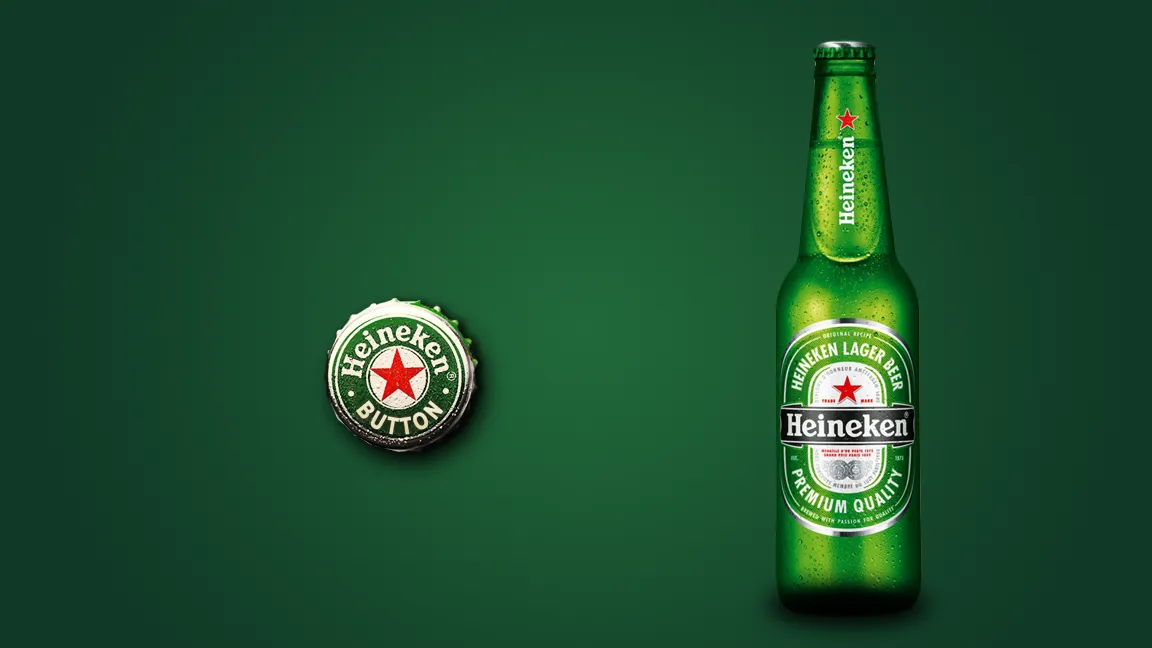 A Heineken bottle and its cap on green.