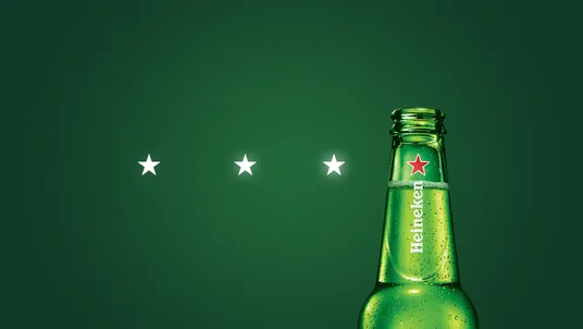Three stars next to the neck of a Heineken bottle on green.