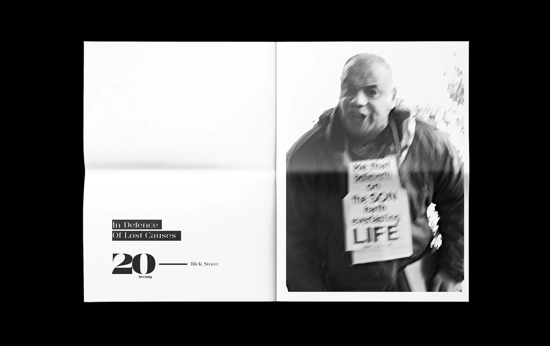 Title spread: 'In Defence of Lost Causes' with the 20twenty masthead on the left page, a man wearing a hand-written sign around his neck on the right.